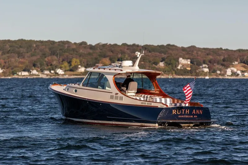 Slide: The Image of 2023 Hinckley Picnic Boat 34 S cruising on water with American flag. - 3