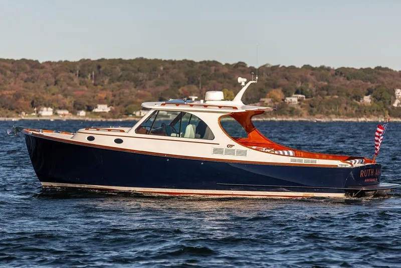 Slide: The Image of 2023 Hinckley Picnic Boat 34 S cruising on a scenic lake. - 5