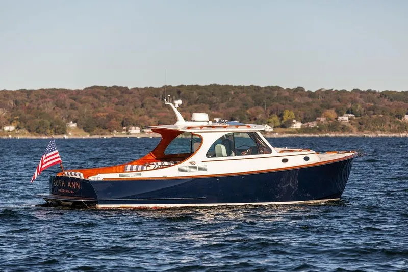Slide: The Image of 2023 Hinckley Picnic Boat 34 S cruising on a scenic lake. - 6