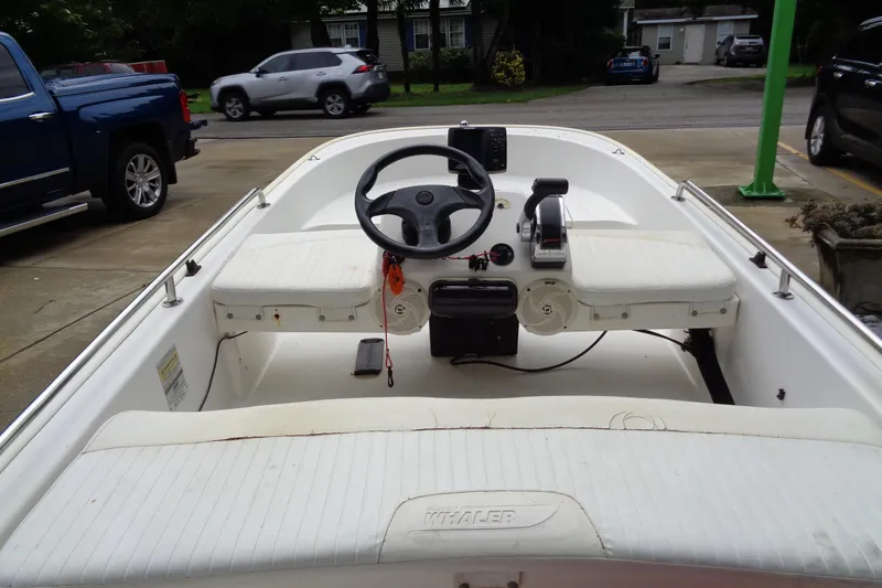 Slide: The Image of 2005 Boston Whaler 110 Sport boat interior with steering wheel and seating. - 11