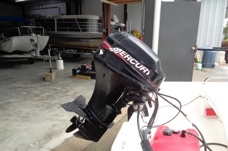 Slide: The Image of 2005 Boston Whaler 110 Sport with Mercury outboard motor in a garage setting. - 5