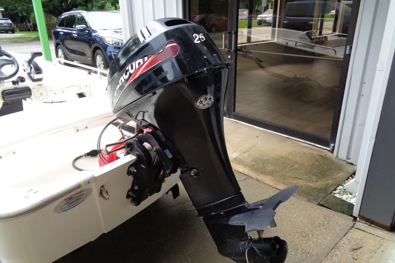 Slide: The Image of 2005 Boston Whaler 110 Sport with Mercury 25 outboard motor, parked near a building. - 7