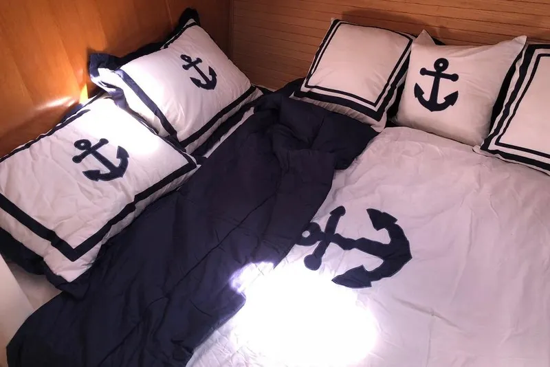 Slide: The Image of Nautical-themed bedding with anchor designs in a 2002 Catalina 42 MkII yacht cabin. - 10