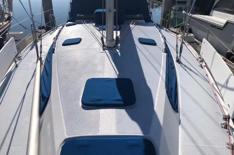 Slide: The Image of 2002 Catalina 42 MkII sailboat deck with blue cushions, docked in marina. - 16