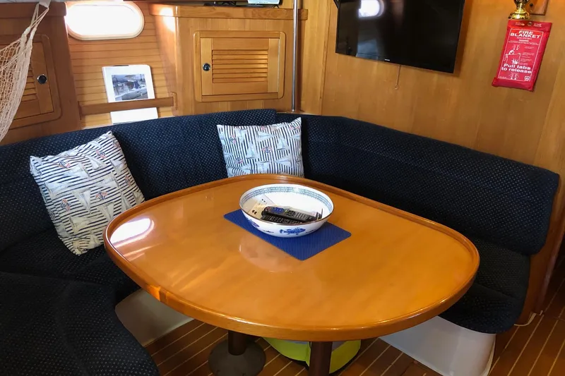 Slide: The Image of Interior of 2002 Catalina 42 MkII yacht with cozy dining area and wooden table. - 2