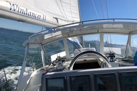 Slide: The Image of Sailing on a 2002 Catalina 42 MkII yacht, "Windancer II," with city skyline in background. - 27