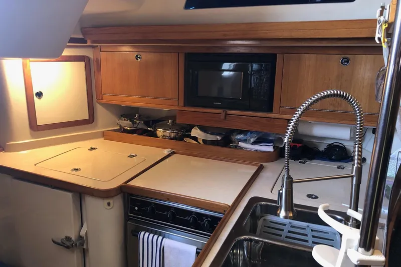 Slide: The Image of Galley kitchen in 2002 Catalina 42 MkII sailboat with wood cabinetry and modern appliances. - 7
