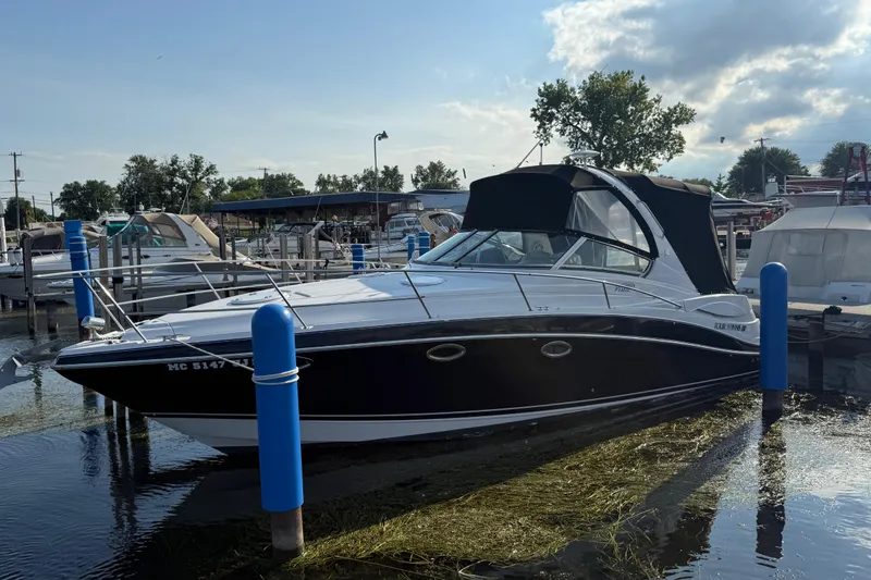 The Image of 2006 Four Winns 318 Vista boat docked at marina under cloudy sky. - 0