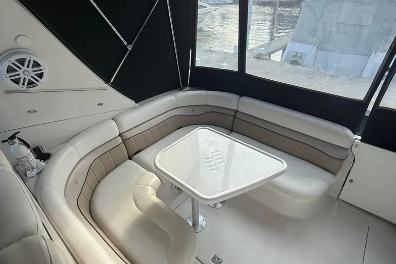 Slide: The Image of 2006 Four Winns 318 Vista boat interior with cushioned seating and table. - 12
