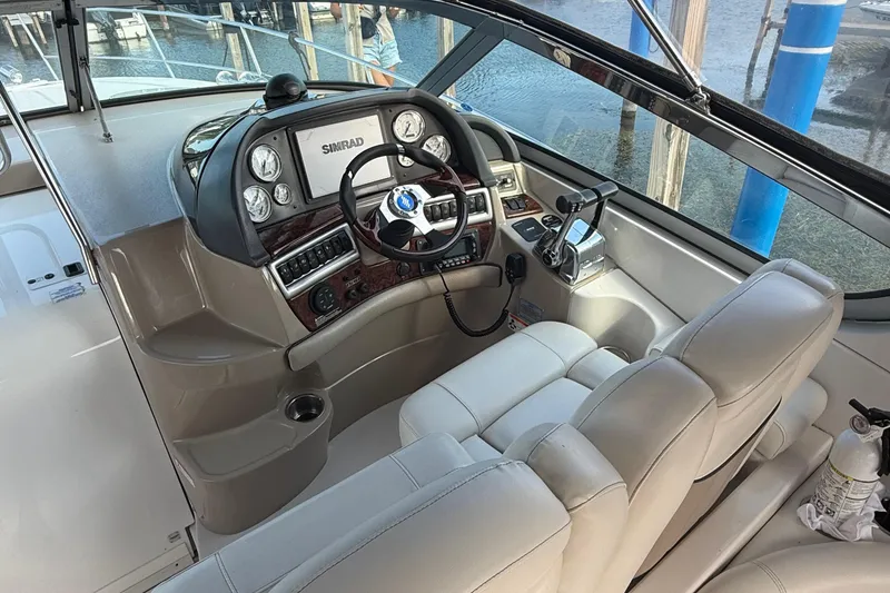 Slide: The Image of 2006 Four Winns 318 Vista boat cockpit with steering wheel and navigation controls. - 19