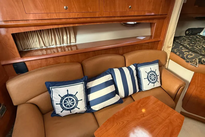 Slide: The Image of 2006 Four Winns 318 Vista interior with nautical-themed cushions and wooden cabinetry. - 25