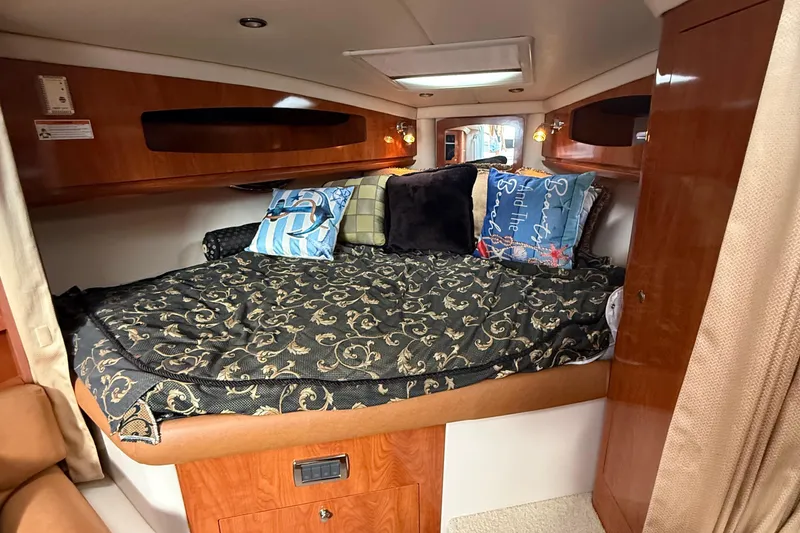 Slide: The Image of 2006 Four Winns 318 Vista cabin interior with cozy bed and decorative pillows. - 26