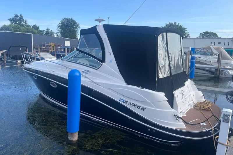 Slide: The Image of 2006 Four Winns 318 Vista boat docked at marina with black canopy. - 4