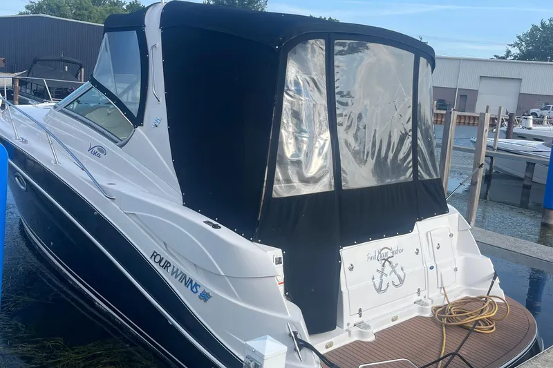 Slide: The Image of 2006 Four Winns 318 Vista boat docked with black canopy and white hull. - 5