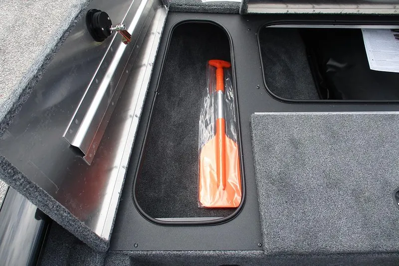 Slide: The Image of Storage compartment in 2026 Tracker Pro Team 175 Crappie Edition boat with orange paddle. - 12