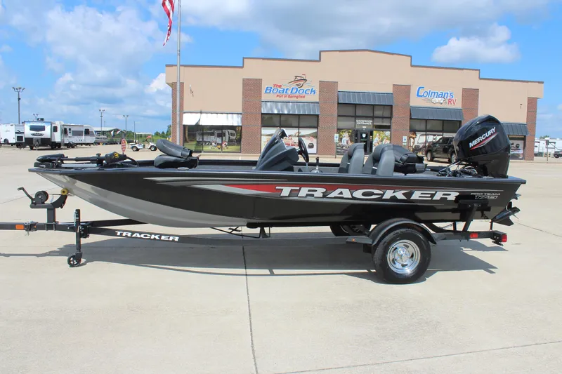 The Image of 2026 Tracker Pro Team 175 boat on trailer, parked outside dealership under blue sky. - 0