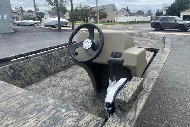 Slide: The Image of 2026 Tracker Grizzly 1648 SC boat with camouflage design and steering console. - 6