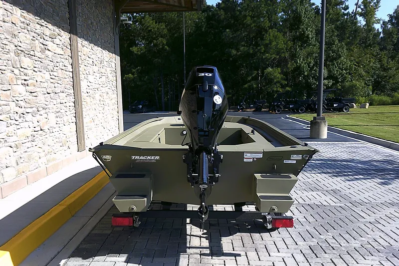Slide: The Image of 2026 Tracker Grizzly 1654 T Sportsman boat on a trailer, parked outdoors. - 3