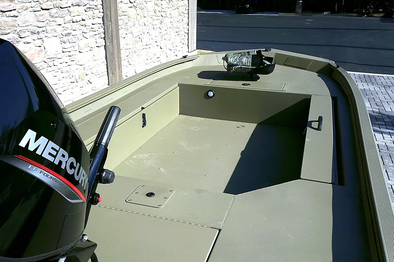Slide: The Image of 2026 Tracker Grizzly 1654 T Sportsman boat with Mercury engine, parked outdoors. - 5