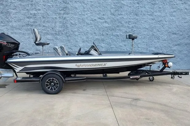 The Image of 2026 Phoenix 818 Pro boat on trailer, side view against a gray wall. - 1
