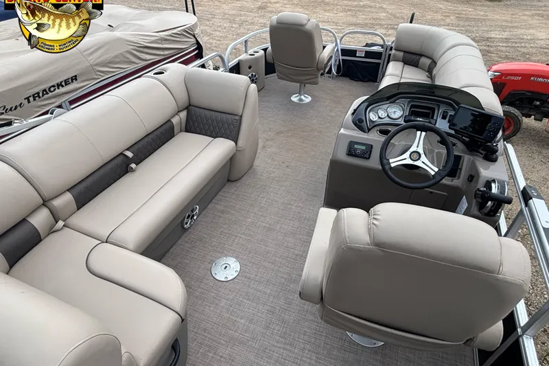 Slide: The Image of 2023 Sun Tracker SportFish 20 DLX pontoon boat interior with beige seating and steering console. - 12