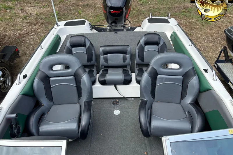 Slide: The Image of 2002 Skeeter SL 190 boat interior with four black seats and a motor at the rear. - 8