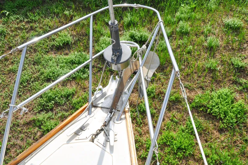 Slide: The Image of Bow of 1984 Sabre 38 MKI sailboat with anchor, surrounded by greenery. - 32