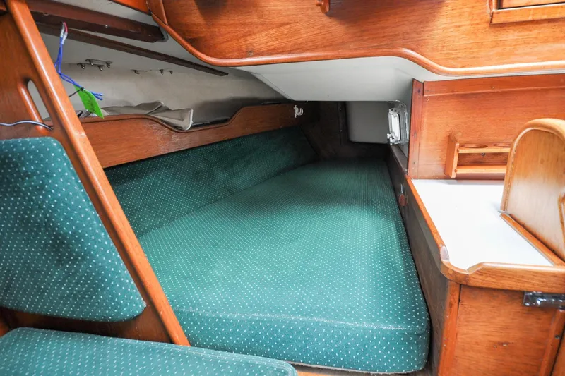 Slide: The Image of 1984 Sabre 38 MKI sailboat interior with green cushioned berth and wooden cabinetry. - 36