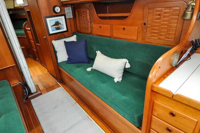 Slide: The Image of Interior of 1984 Sabre 38 MKI sailboat with green cushioned seating and wooden cabinetry. - 43