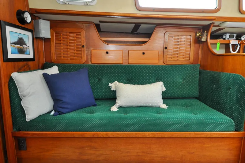 Slide: The Image of Interior of 1984 Sabre 38 MKI sailboat with green cushioned seating and decorative pillows. - 45