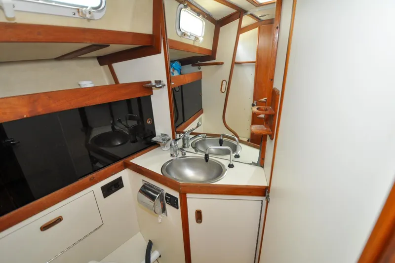 Slide: The Image of 1984 Sabre 38 MKI yacht bathroom with dual sinks and wooden accents. - 59