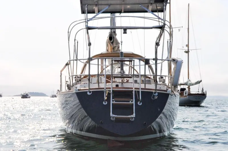 Slide: The Image of 1984 Sabre 38 MKI sailboat anchored on calm water, viewed from the stern. - 6