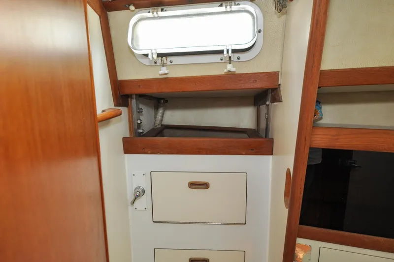 Slide: The Image of Interior of 1984 Sabre 38 MKI sailboat with wooden cabinetry and storage drawers. - 62