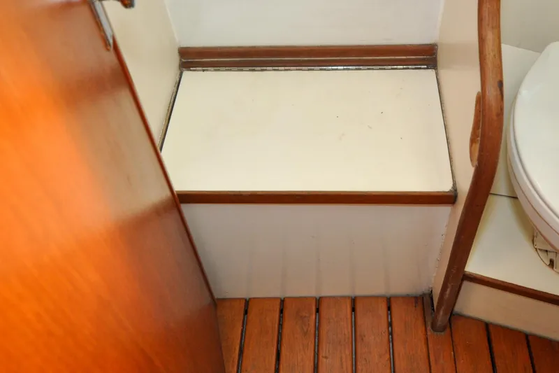 Slide: The Image of Interior of 1984 Sabre 38 MKI sailboat showing wooden flooring and compact bathroom area. - 63