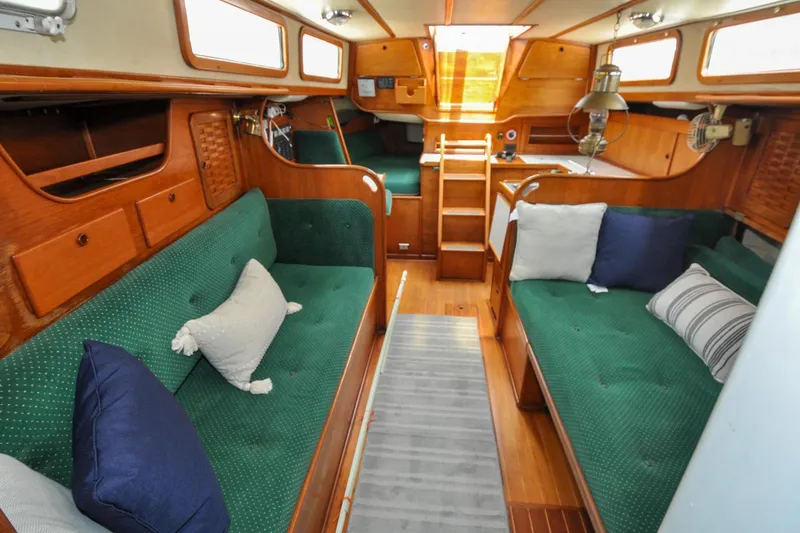 Slide: The Image of Interior of 1984 Sabre 38 MKI sailboat with green cushioned seating and wooden finishes. - 64