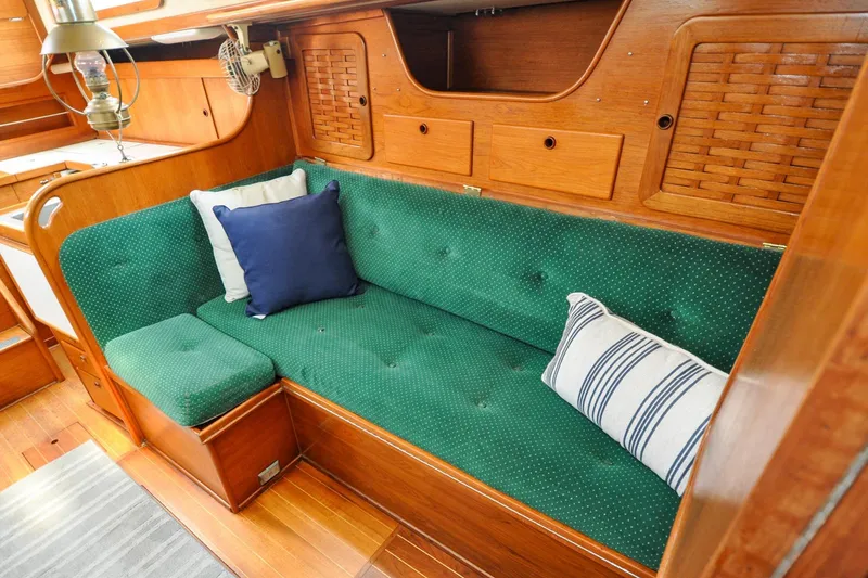 Slide: The Image of Interior of 1984 Sabre 38 MKI sailboat with green cushioned seating and wooden cabinetry. - 65