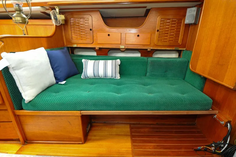 Slide: The Image of Interior of 1984 Sabre 38 MKI sailboat with green cushioned seating and wooden cabinetry. - 68