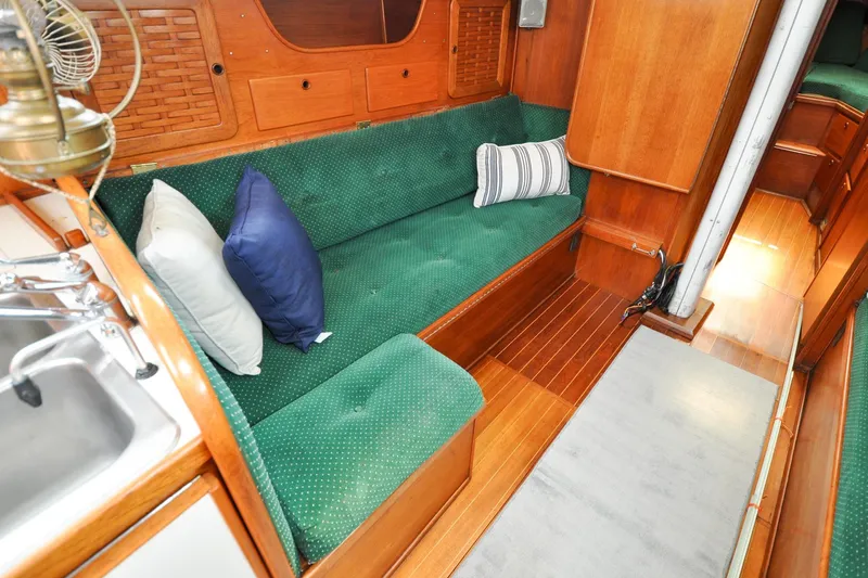 Slide: The Image of Interior of 1984 Sabre 38 MKI sailboat with green cushioned seating and wooden finishes. - 69