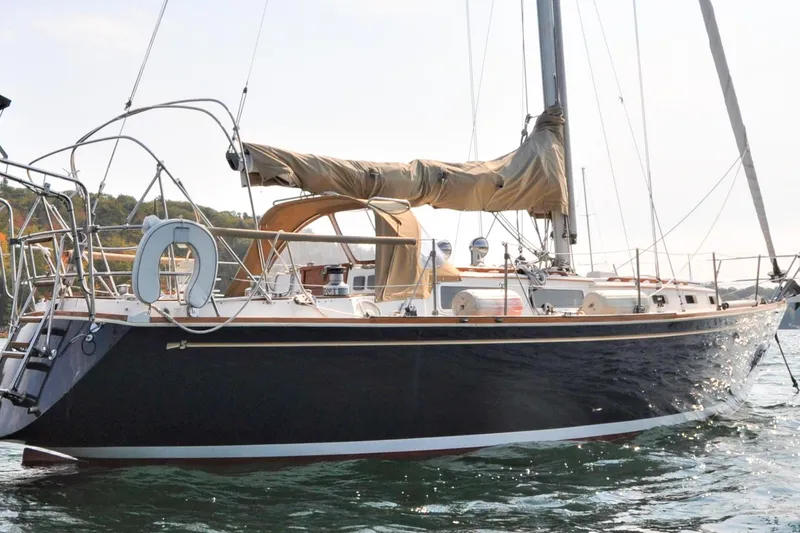 Slide: The Image of 1984 Sabre 38 MKI sailboat on water, featuring classic design and covered sails. - 7