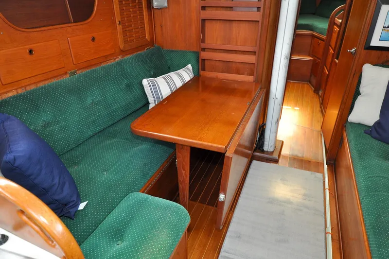 Slide: The Image of 1984 Sabre 38 MKI yacht interior with green upholstery and wooden table. - 70