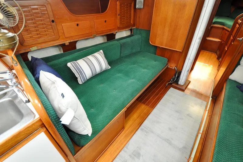 Slide: The Image of Interior of 1984 Sabre 38 MKI sailboat with green cushioned seating and wooden finish. - 72