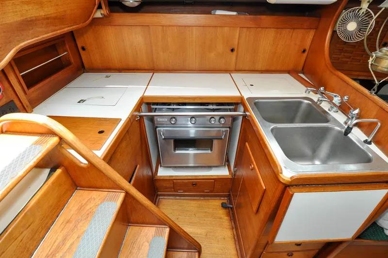 Slide: The Image of 1984 Sabre 38 MKI yacht kitchen with stove, double sink, and wooden cabinetry. - 73