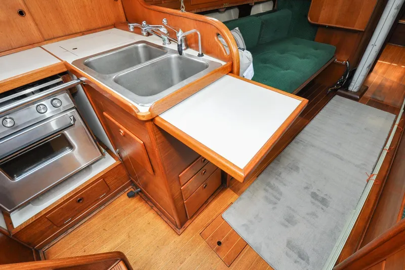 Slide: The Image of 1984 Sabre 38 MKI yacht interior with kitchen sink, stove, and wooden cabinetry. - 74