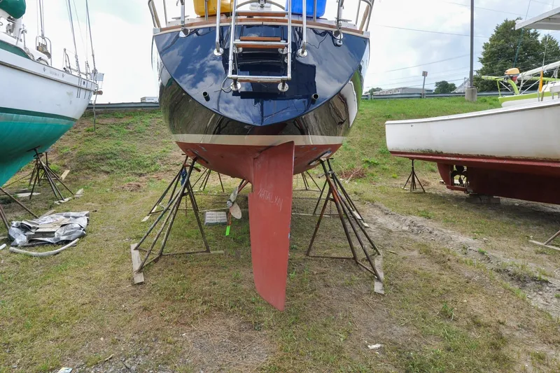 Slide: The Image of 1984 Sabre 38 MKI sailboat on stands, showcasing hull and keel in a boatyard. - 87