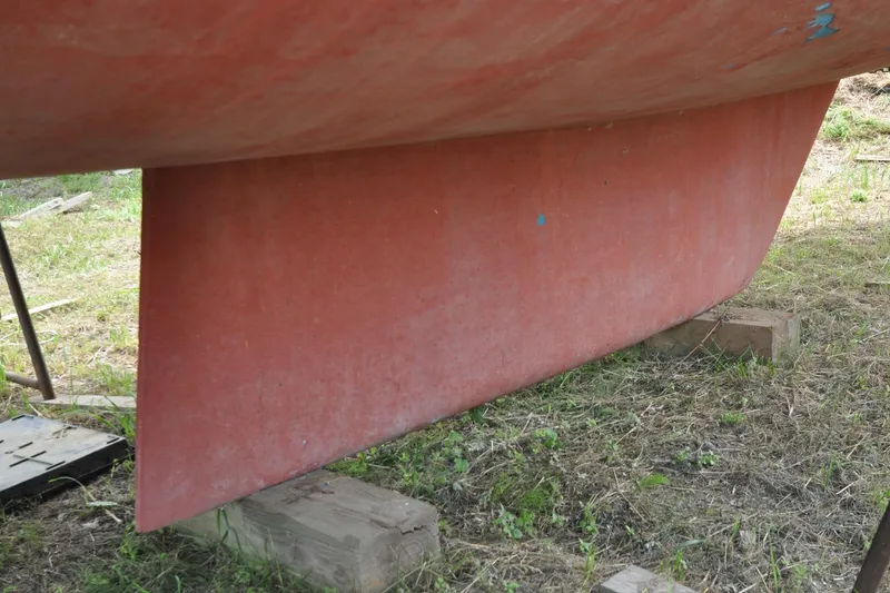 Slide: The Image of Red keel of 1984 Sabre 38 MKI sailboat on wooden blocks. - 89