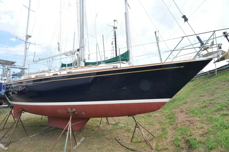 Slide: The Image of 1984 Sabre 38 MKI sailboat on stands, black hull, red bottom, outdoor setting. - 91