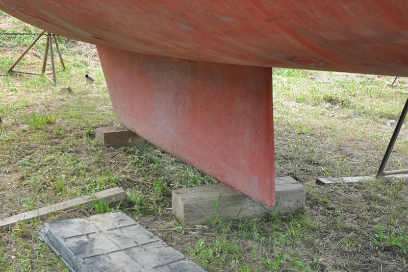 Slide: The Image of Keel of 1984 Sabre 38 MKI sailboat on dry land, supported by wooden blocks. - 94