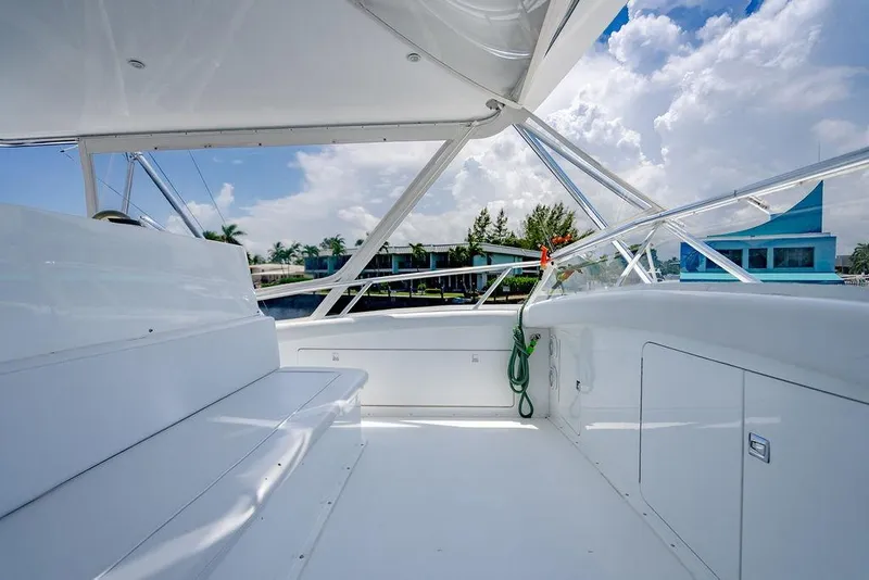 Slide: The Image of 1998 Bertram Convertible yacht interior with white seating and clear skies. - 13