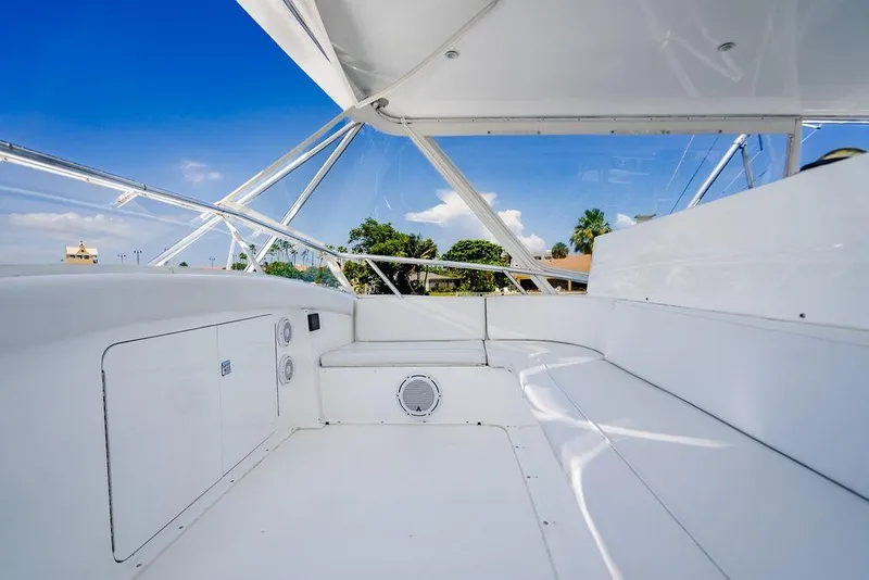 Slide: The Image of 1998 Bertram Convertible boat interior with white seating and clear blue sky. - 14