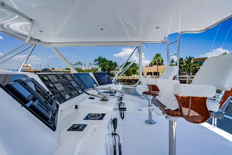 Slide: The Image of 1998 Bertram Convertible yacht cockpit with steering wheel, control panels, and luxurious seating. - 16